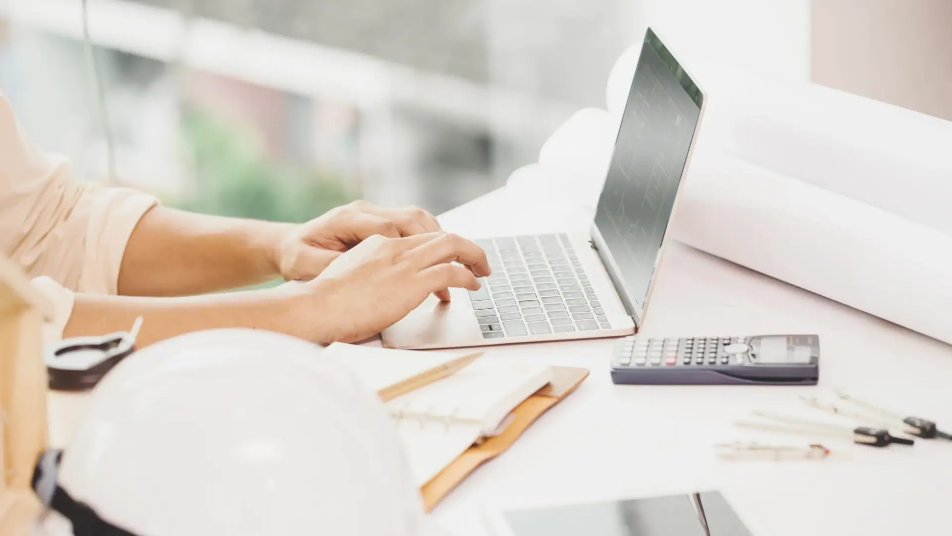 Mesa con planos, calculadora y documentos para tomar decisiones inmobiliarias